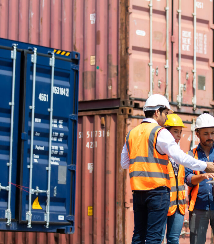 Hispanic man harbor worker talking on the walkie-talkie radio an Hispanic man harbor worker talking on the walkie-talkie radio and control loading containers at container warehouse. container yard port of import and export goods